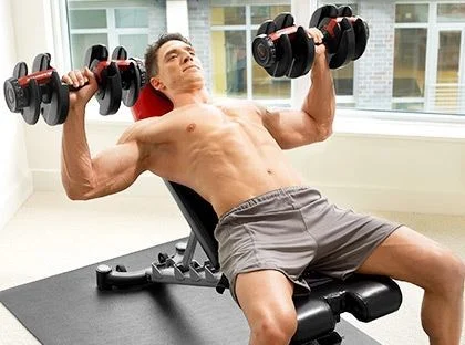 Man doing a bench press workout in a home gym
