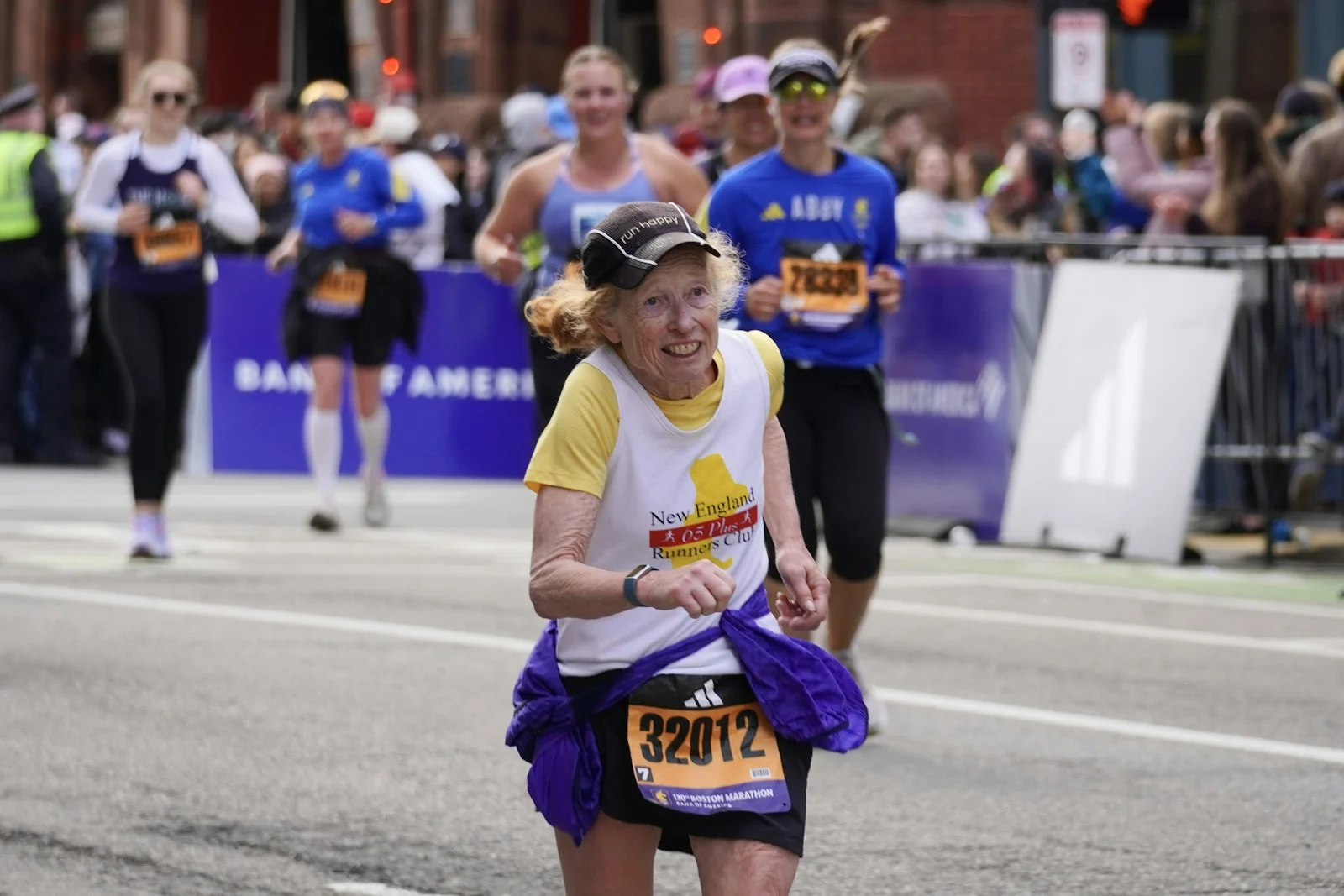 Older woman smiling while running a marathon