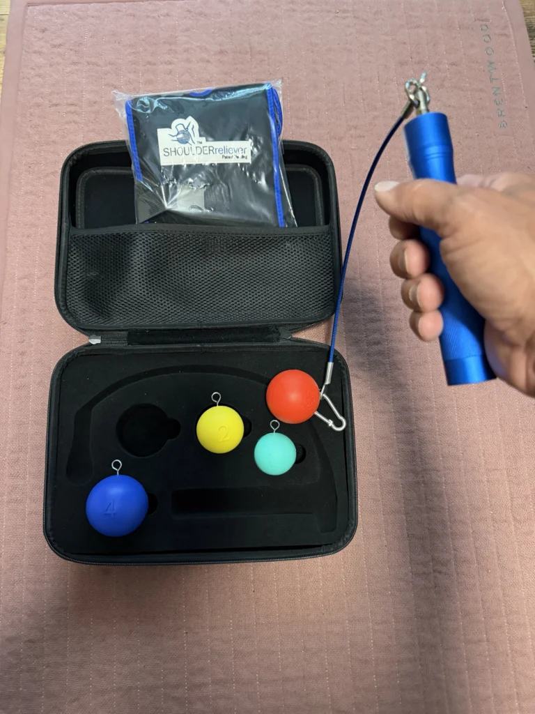 Holding the Shoulder Reliever handle with the red number 3 ball clipped to the cable, balls 1, 2 and 4 still in the case
