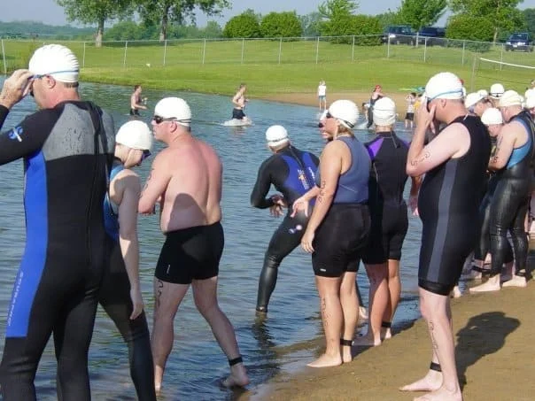Eric Ellis holding his GPS watch during a triathlon swim